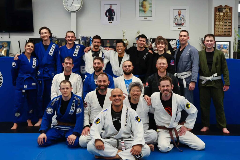 A group photo of students from Renzo Gracie Latham. In the photo, Brazilian Jiu-Jitsu professor Bruno Tostes sits at the front.